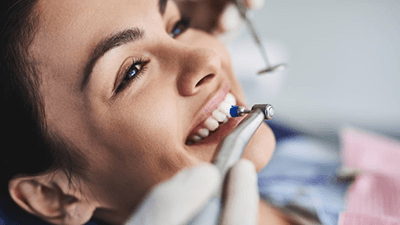 a woman visiting her dentist to maintain teeth whitening results