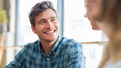 man smiling while talking to person