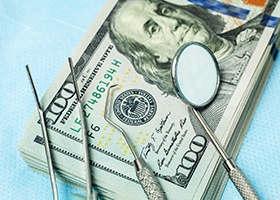 money with dental tools on table