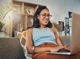 Smiling woman using laptop on couch