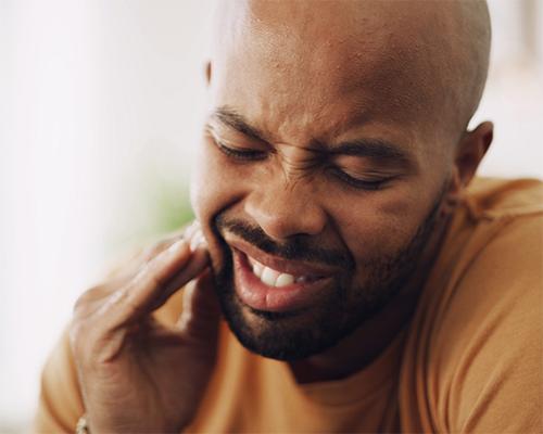Man holding side of his jaw in pain