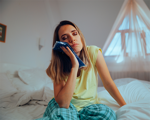 Woman holding an ice pack to her face
