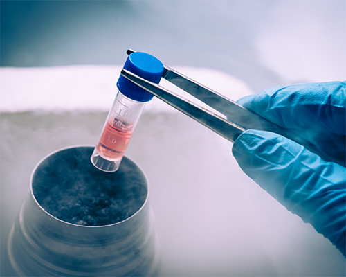 Scientist dipping a vial into a blue solution