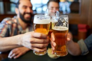 Group of people clinking glasses of beer together