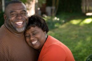 Smiling couple with dentures in Irving together outside