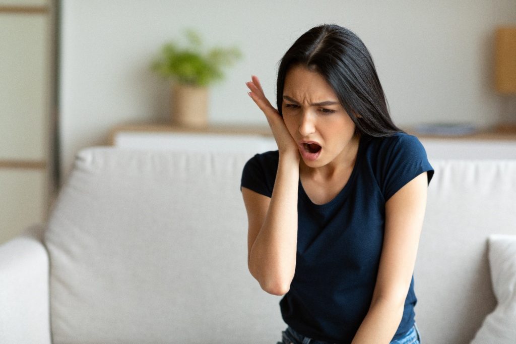 Woman experiencing a knocked-out tooth.