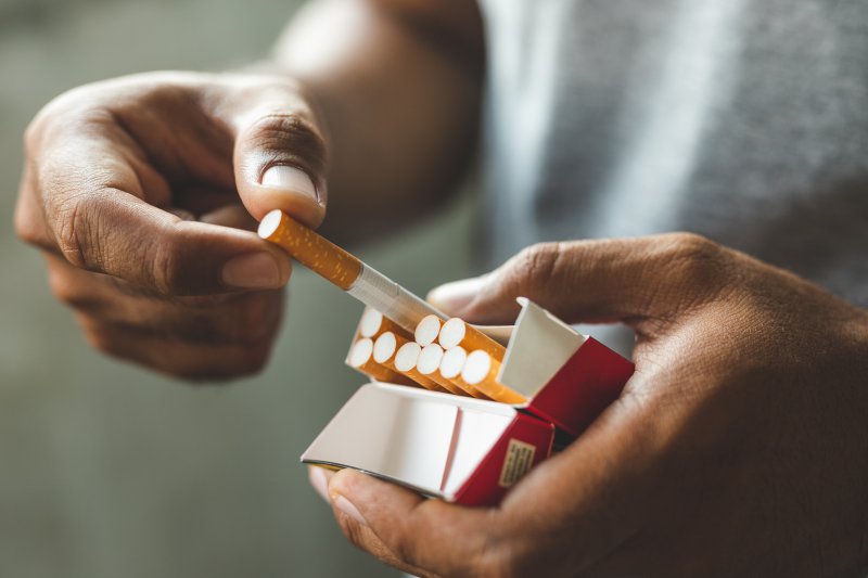 person pulling out a cigarette