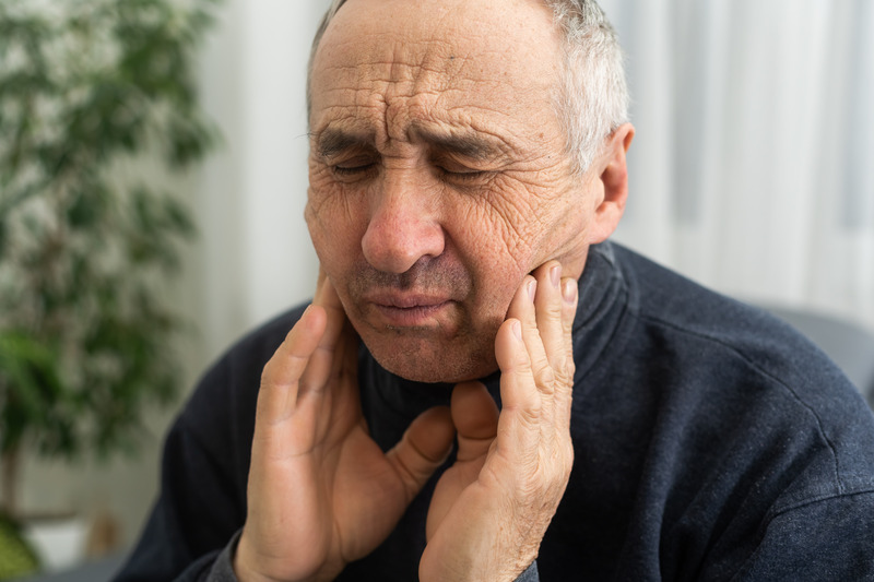 Patient holding jaw due to TMJ disorder