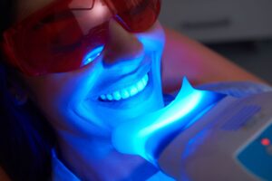 Close-up of UV light applied to woman's teeth whitening